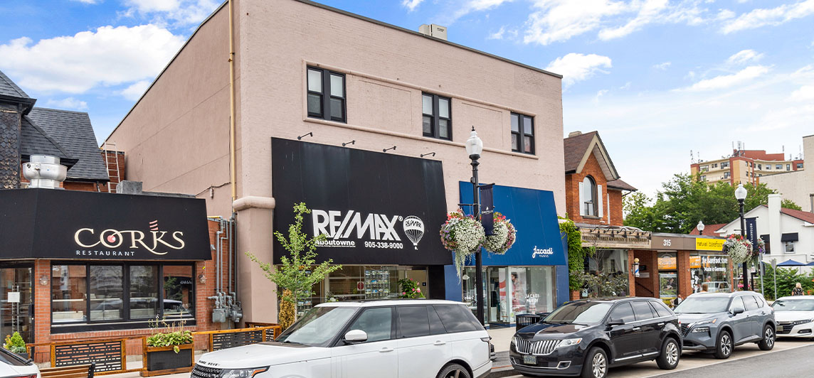 Street level view of 309 Lakeshore Road East's storefront. A two storey light beige concrete facade.